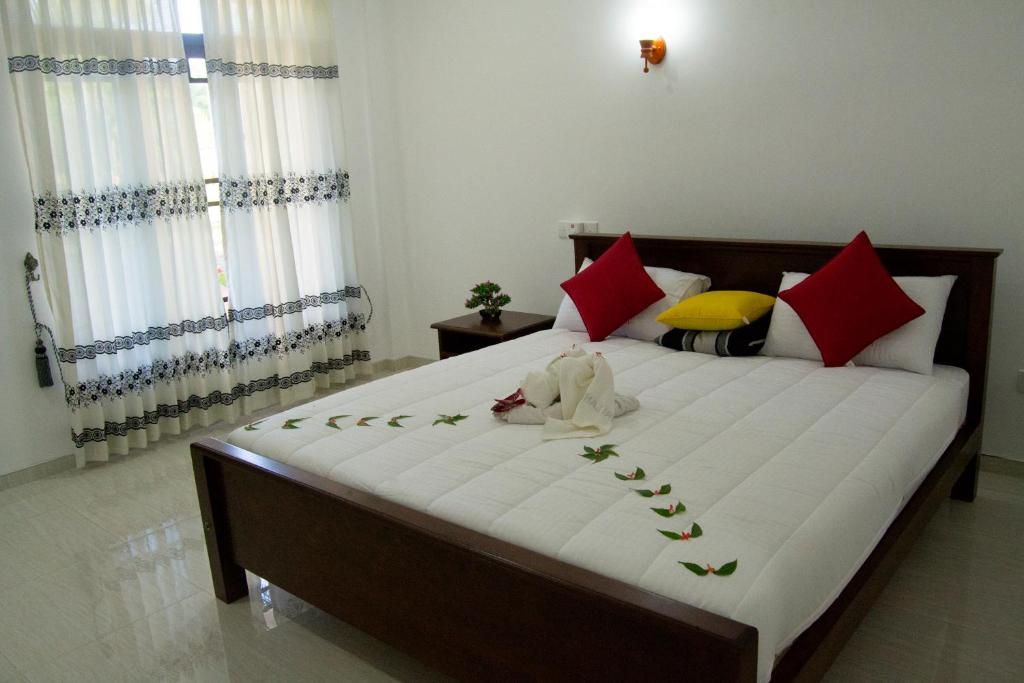 Deluxe Double Room at Shady Mango Villa β comfortable bed with red and white pillows